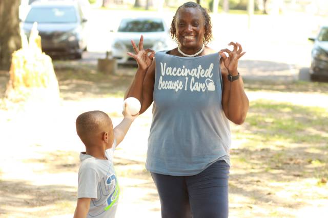 Woman with a shirt that says "Vaccinated Because I Care"