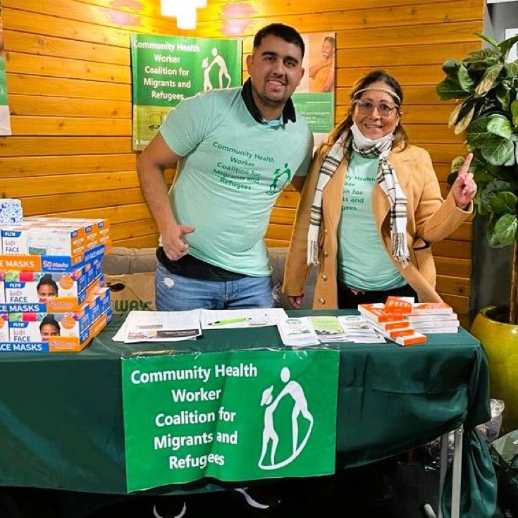 Two people working at a community health booth