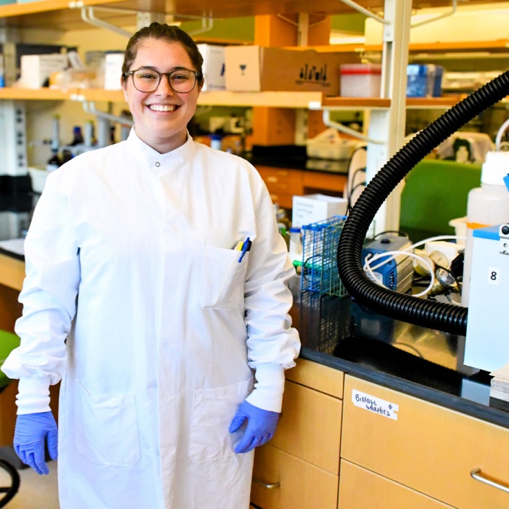 A smiling person in a lab setting