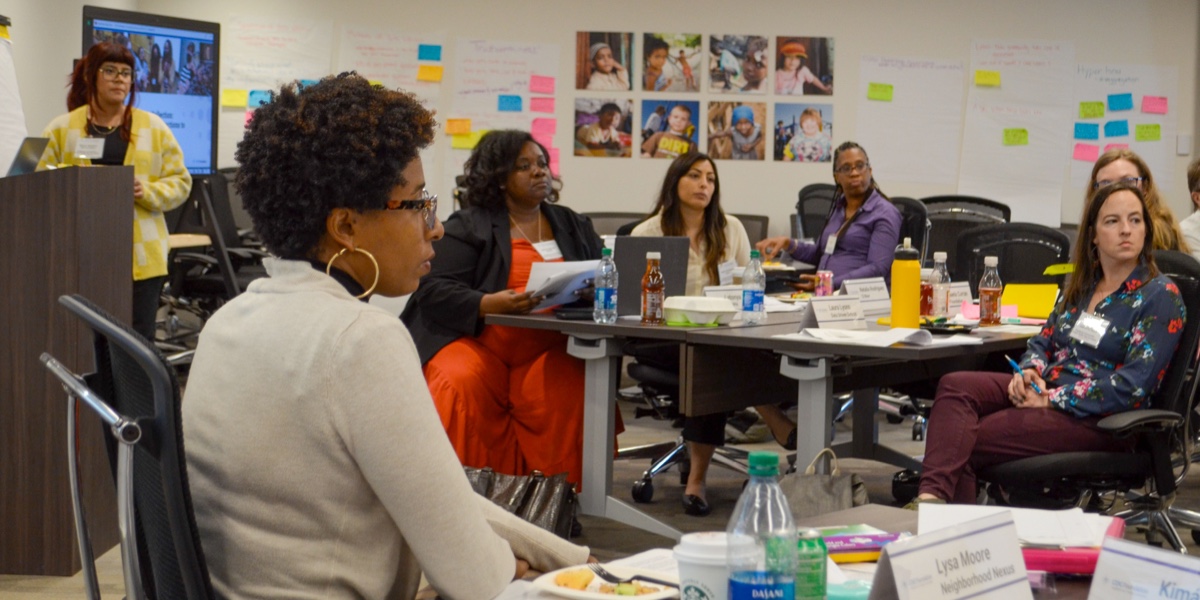 A group of people speaking in a classroom setting