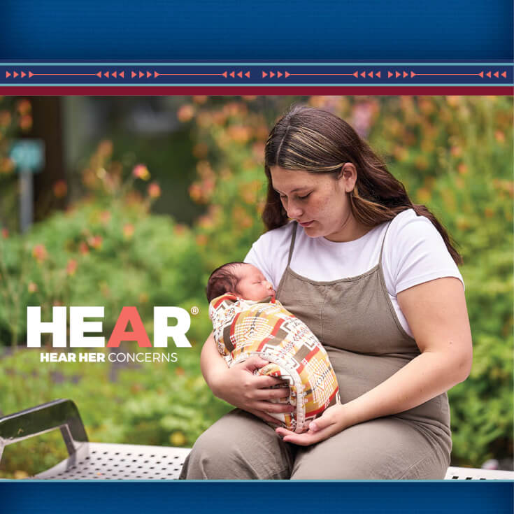 A person holding a baby with watermark that says Hear Her Concerns