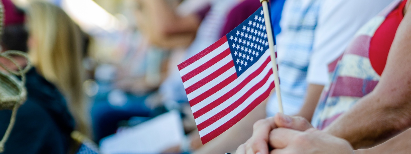 A person holding a small American flag