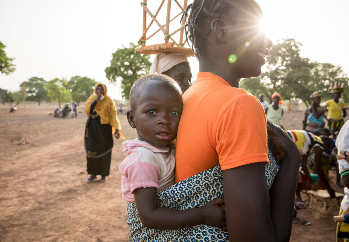 An image of a child being carried on a person's back