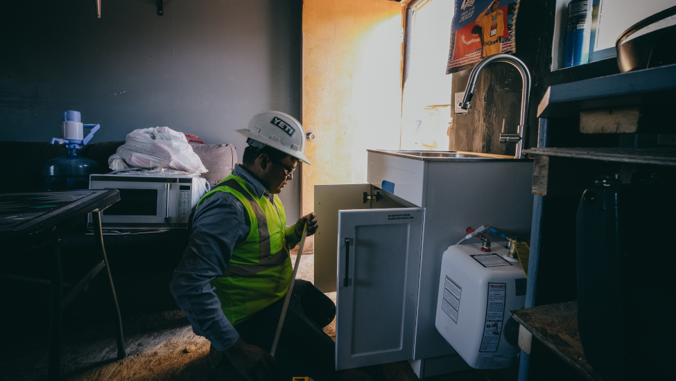 A staff member installing a sink in a client’s home.