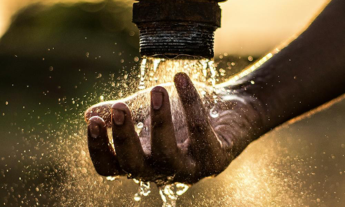 A hand under a running water faucet