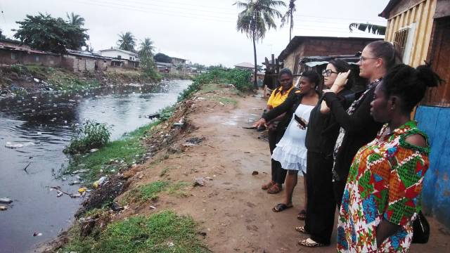 Danielle Fernandez, CDC Foundation health scientist and Dr. Tessa Clemens, CDC health scientist join a data collector and community health workers to examine a ditch in the Kotobabi community, Accra, Ghana.