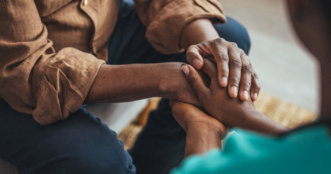 A close up image of two African American people holding hands