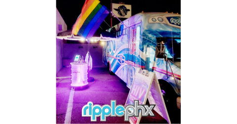 A bus with a rainbow flag and a sign out fron that says HIV testing. RipplePHX logo has been added.