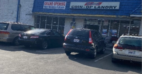 Cars parked outside a laundromat. 
