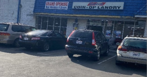 Cars parked outside a laundromat.